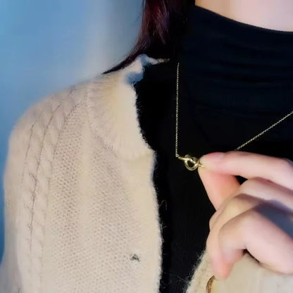 Orek Heart Love Knot Necklace necklace on jewellery display, an interlocking heart and love-knot pend