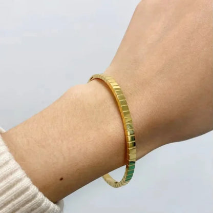 Close-up of Orek Bold Radiance Square Edge Bangle bracelet detail, a textured surface set against sharp, sq
