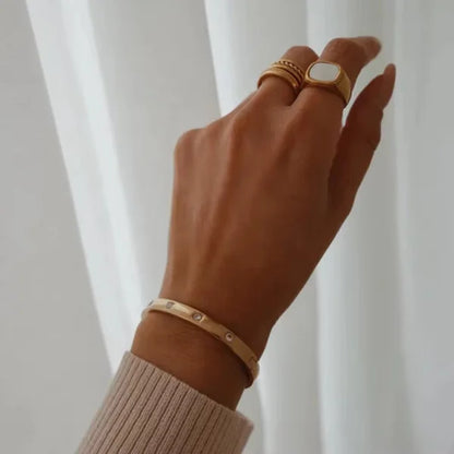 Close-up of Orek Luna Luxe Gold Bangle bracelet detail, a smooth, high-polish cuff with a rounde