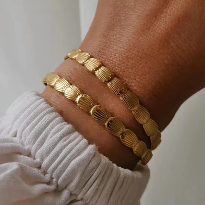 Close-up of Orek Sora Luxe Adjustable Bangle bracelet detail, a shell-shaped curve with a smooth, scul