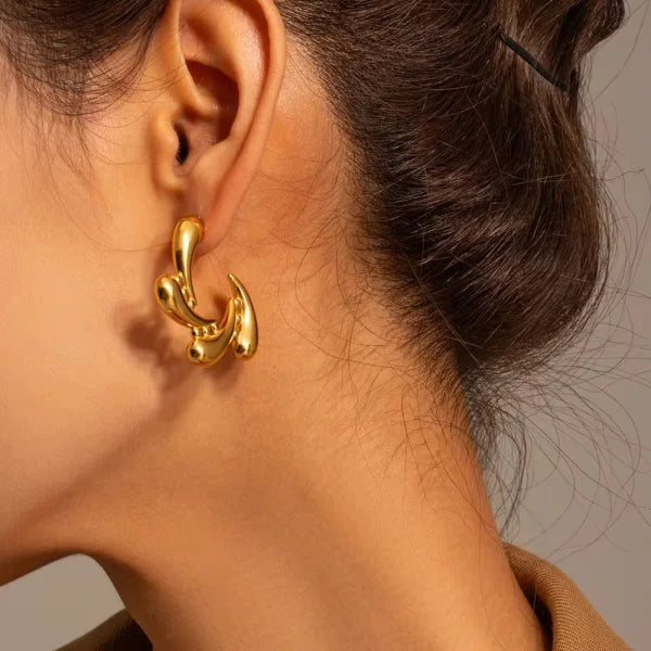 Orek Golden Bloom Drop Earrings earrings on jewellery display, a rotating water-drop pendant that catch