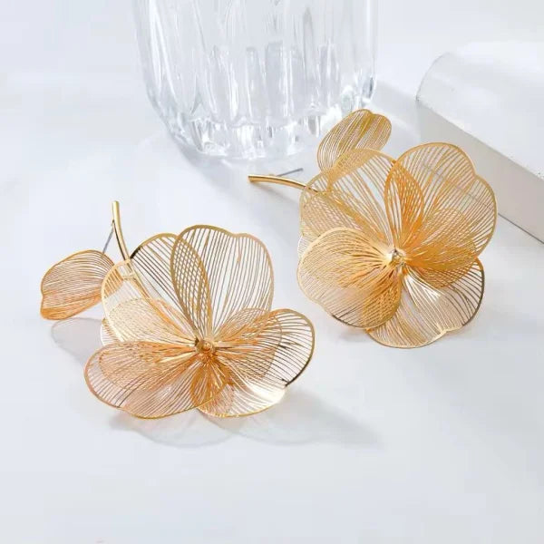 Orek Ivra Bold Flora Dangler earrings on jewellery display, a large, textured flower silhouette with
