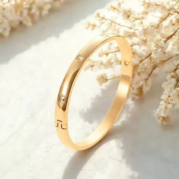 Orek Luna Luxe Gold Bangle bracelet on jewellery display, a smooth, high-polish cuff with a rounde