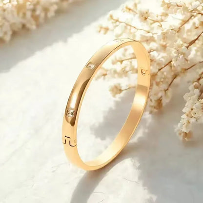 Orek Luna Luxe Gold Bangle bracelet on jewellery display, a smooth, high-polish cuff with a rounde