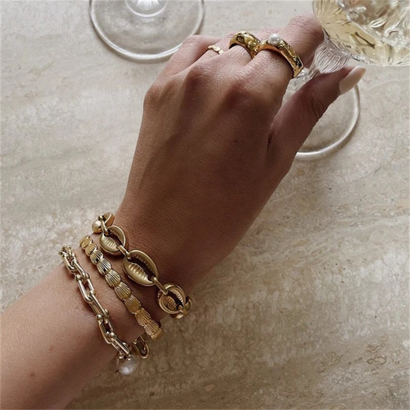 Orek Sora Luxe Adjustable Bangle bracelet on jewellery display, a shell-shaped curve with a smooth, scul