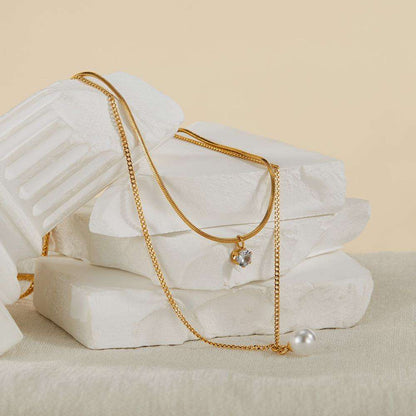 Close-up of Orek Evara Twin Grace Necklace necklace detail, a dual-layer chain finished with a pearl