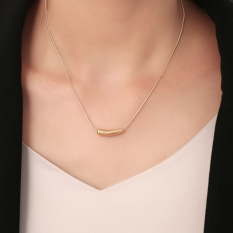 Orek Solyn Curved Arc Necklace necklace on jewellery display, a sculpted, curved-tube pendant with a s