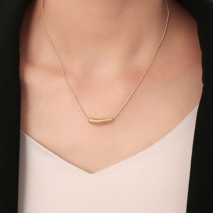 Orek Solyn Curved Arc Necklace necklace on jewellery display, a sculpted, curved-tube pendant with a s