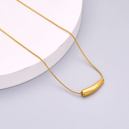 Close-up of Orek Solyn Curved Arc Necklace necklace detail, a sculpted, curved-tube pendant with a s