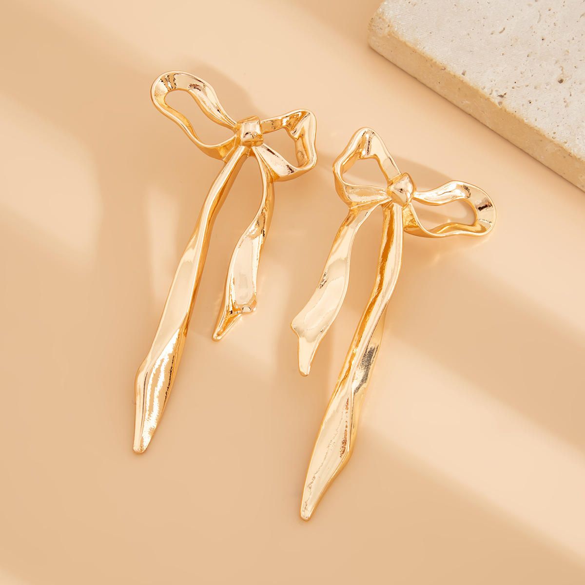 Close-up of Orek Noira Bold Bow Dangler earrings detail, an exaggerated, elongated bow silhouette