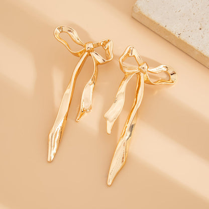 Close-up of Orek Noira Bold Bow Dangler earrings detail, an exaggerated, elongated bow silhouette