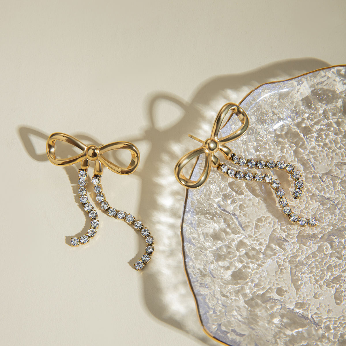 Close-up of Orek Elara Bow Earrings earrings detail, a bow-shaped top finished with a long, d