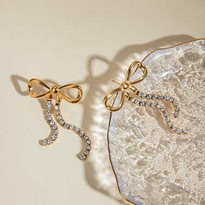 Close-up of Orek Elara Bow Earrings earrings detail, a bow-shaped top finished with a long, d