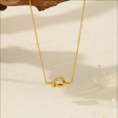 Woman wearing Orek Heart Love Knot Necklace necklace