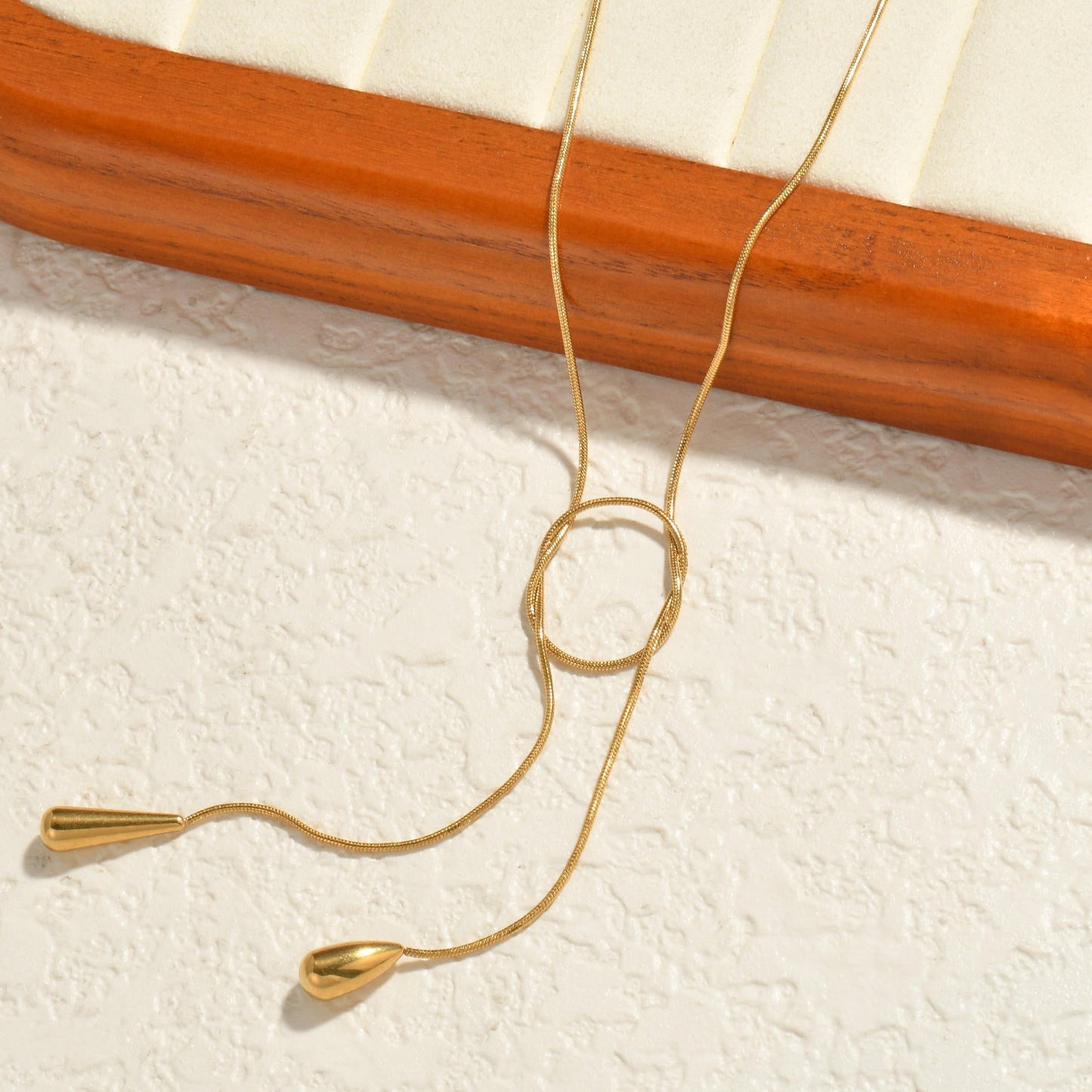 Orek Evara Loop Drop Necklace necklace on jewellery display, an adjustable lariat-style chain that lo