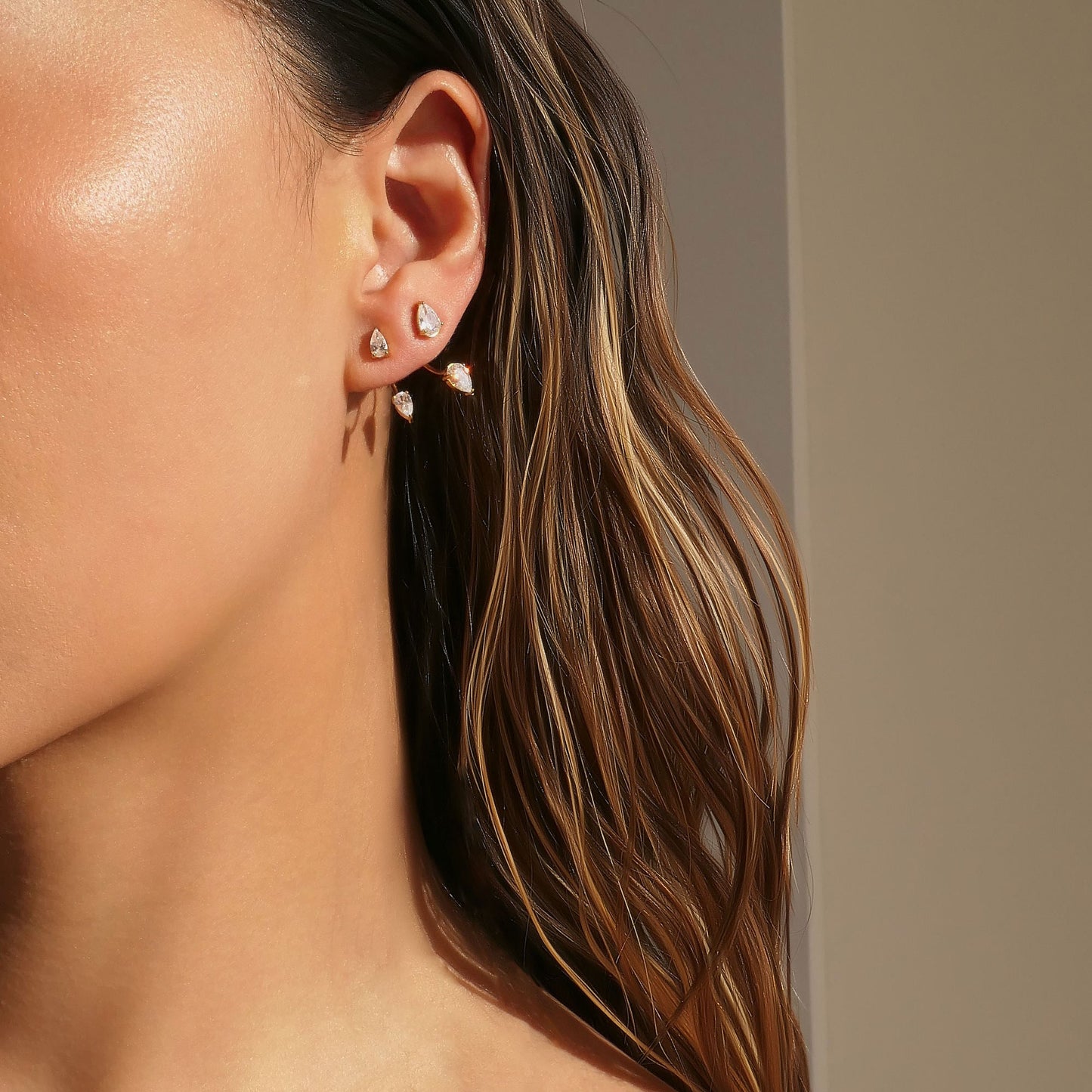 Close-up of Orek Era Pear Crystal Studs earrings detail, a pear-cut crystal set in a removable, c