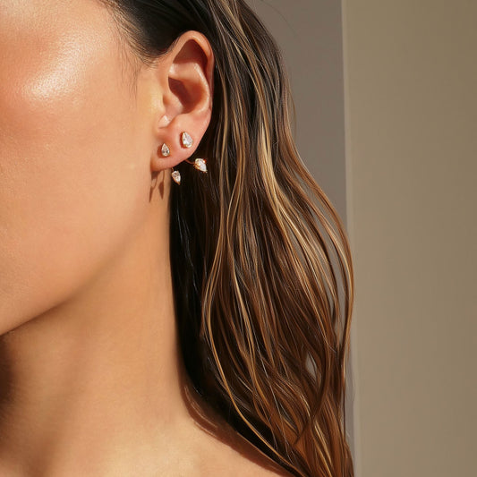 Close-up of Orek Era Pear Crystal Studs earrings detail, a pear-cut crystal set in a removable, c