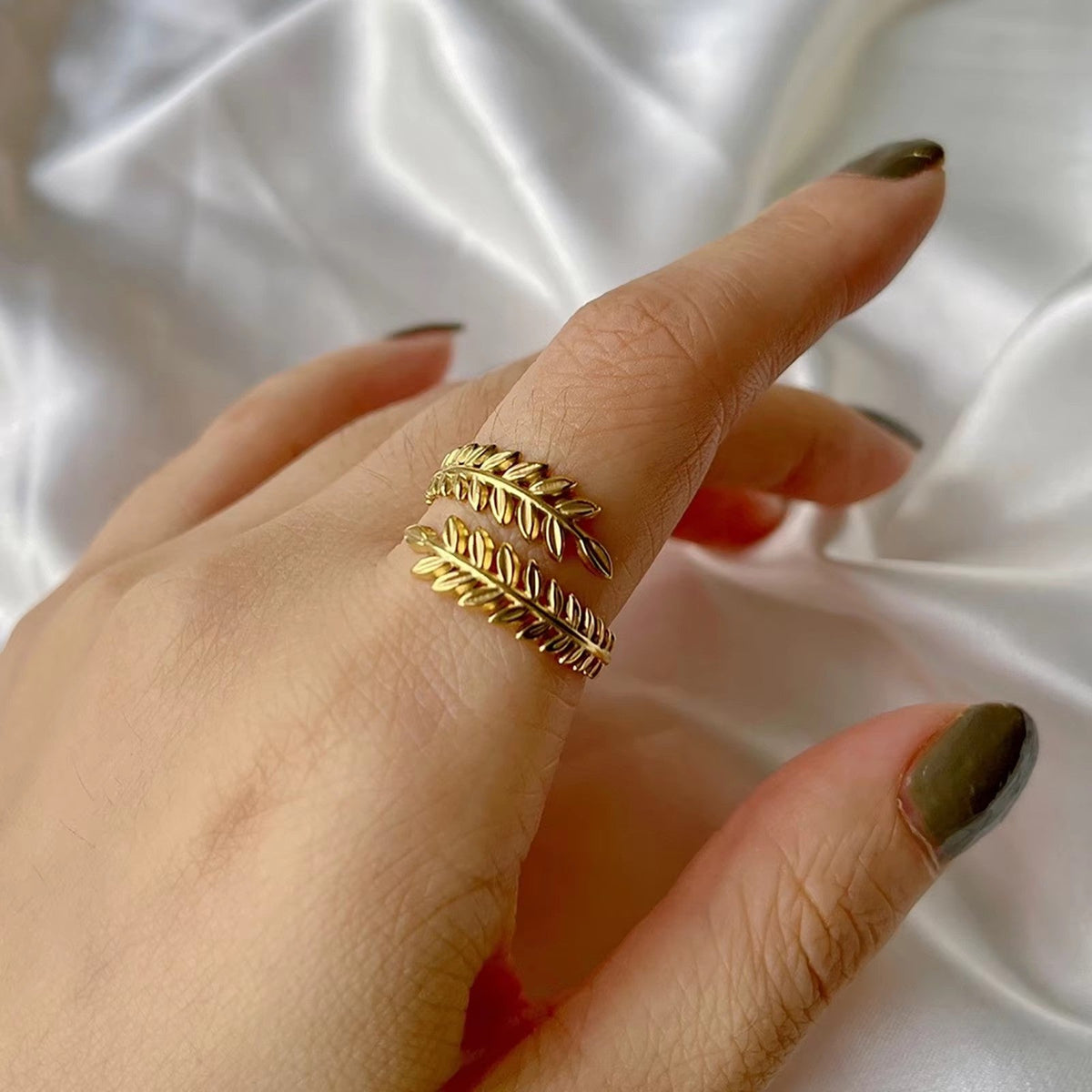 Close-up of Orek Foliage Leaf Ring ring detail, an asymmetric leaf silhouette wrapping g