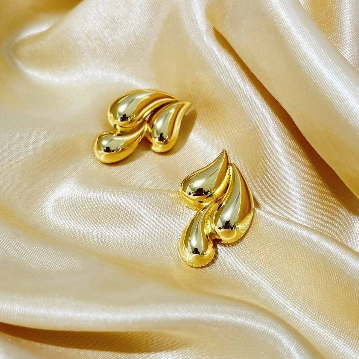 Close-up of Orek Golden Swirl Drop Earrings earrings detail, a fluid, swirling drop that catches ligh