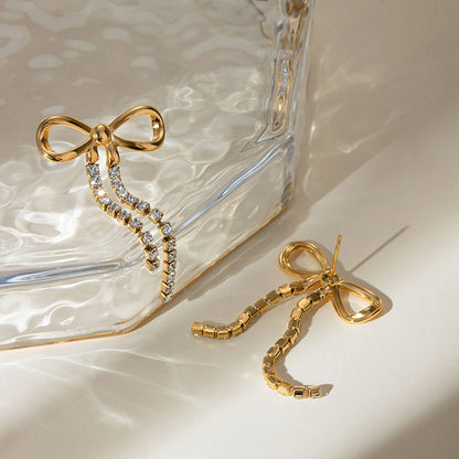 Orek Elara Bow Earrings earrings on jewellery display, a bow-shaped top finished with a long, d