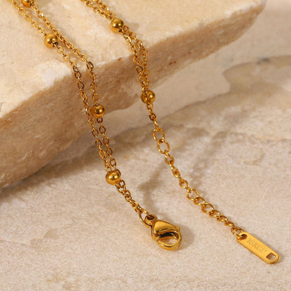 Orek Ira Double Chain Bracelet bracelet on jewellery display, two fine chains layered with a row of sm