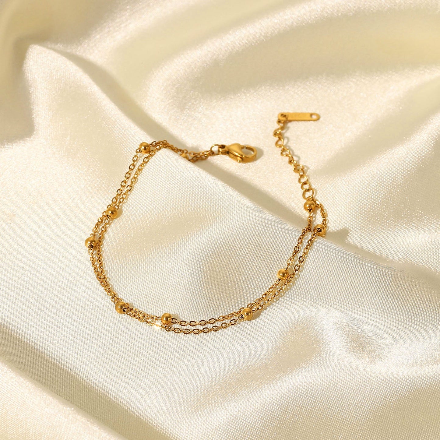 Close-up of Orek Ira Double Chain Bracelet bracelet detail, two fine chains layered with a row of sm