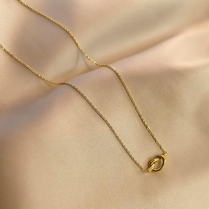 Woman wearing Orek Heart Love Knot Necklace necklace