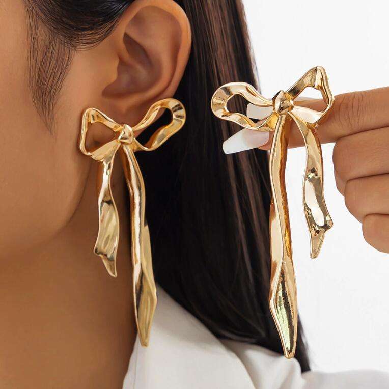 Woman wearing Orek Noira Bold Bow Dangler earrings