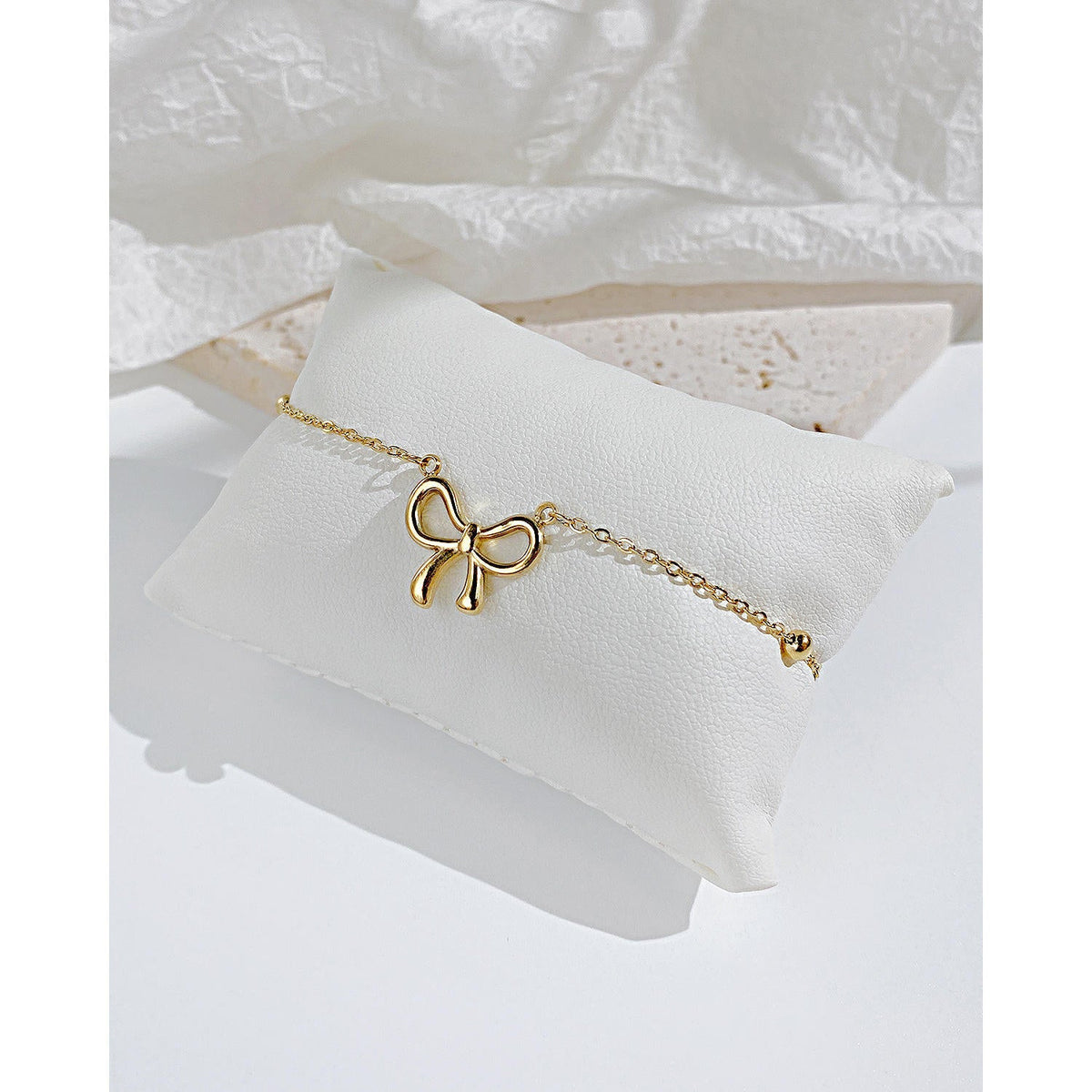 Woman wearing Orek Golden Bow Charm Bracelet for everyday styling