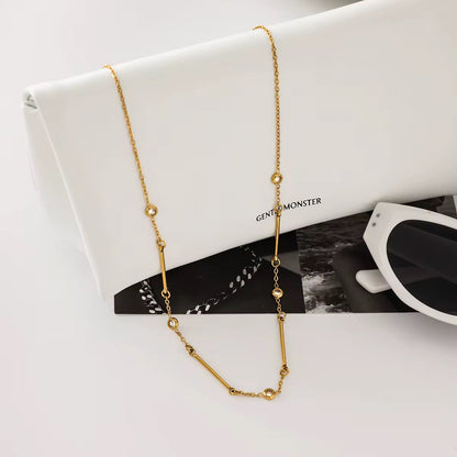 Close-up of Orek Ira Linear Charm Necklace, showing anti-tarnish gold plated finish