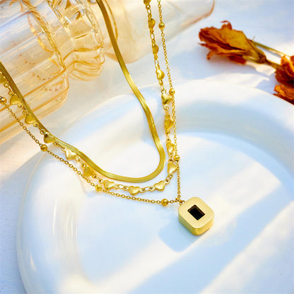 Close-up of Orek Noira Heart Layers Necklace with green heart pendant