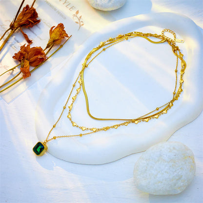 Woman wearing Orek Noira Heart Layers Necklace with layered gold chains