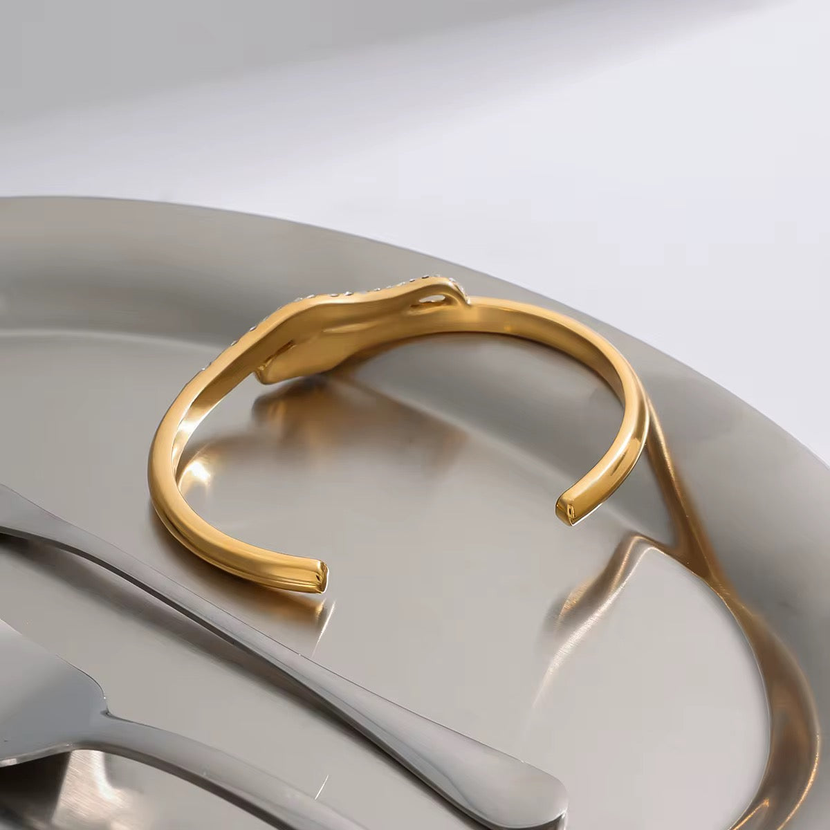 Close-up of Orek Zeni Serpent Arc Bangle showing pavé serpent design